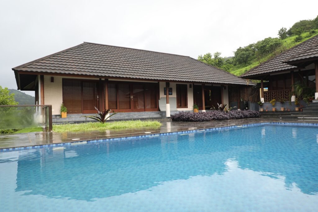 Contemporary resort villa with a swimming pool, nestled in lush greenery, exuding tranquility.