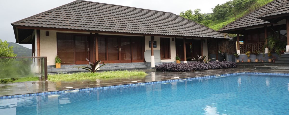 Contemporary resort villa with a swimming pool, nestled in lush greenery, exuding tranquility.